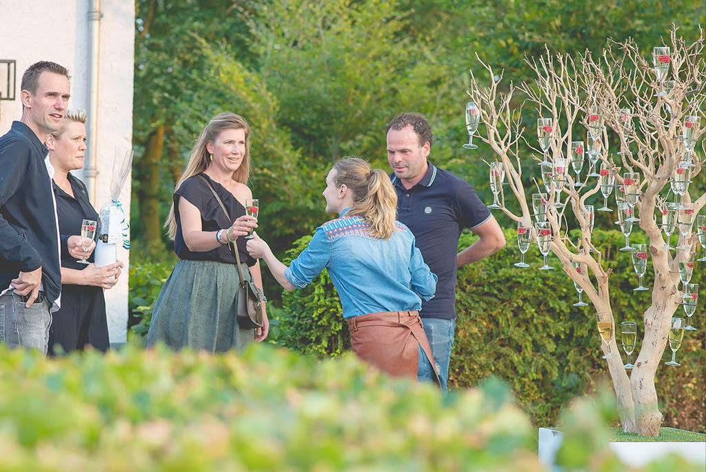 Ober met champagneboom op prive tuinfeest